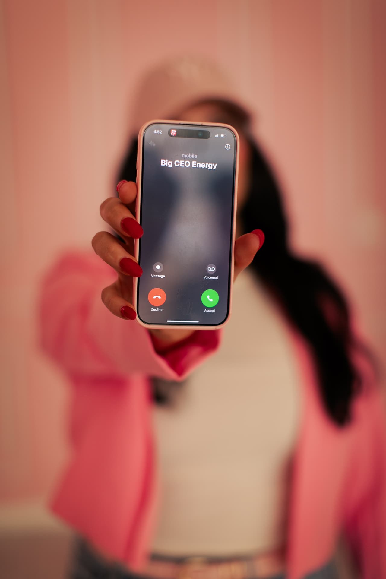 Marissa holding up a phone with an incoming call from 'Big CEO Energy'